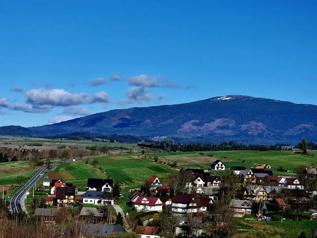 Widok na wieś u podnóża Babiej Góry. Zastanawiasz się, jakim szlakiem na Babią Górę?