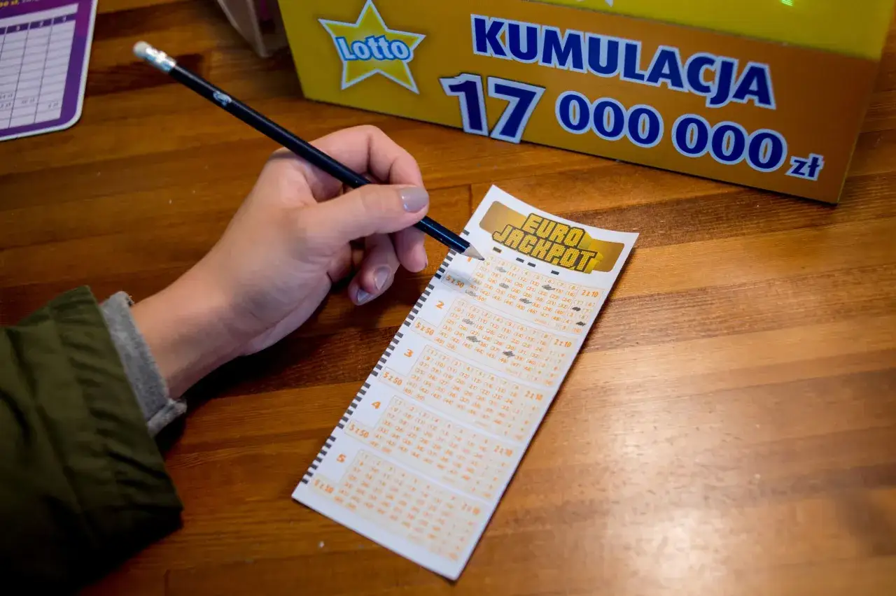 Ręka z ołówkiem zaznacza liczby na kuponie Eurojackpot. Czy nagroda w loterii pożyczkowej jest zwolniona z podatku od wzbogacenia?