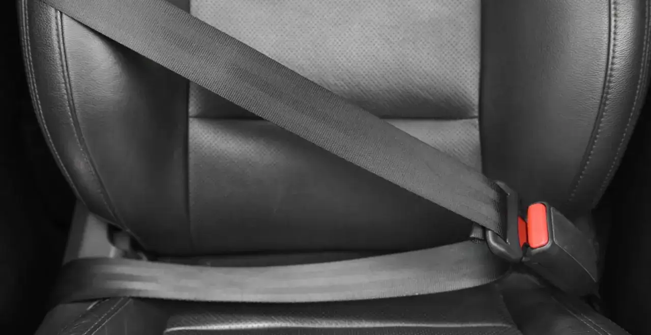 Pasek bezpieczeństwa na czarnym, skórzanym siedzeniu. Dowiedz się, jak naprawić zwijacz pasów bezpieczeństwa, gdy przestanie działać.