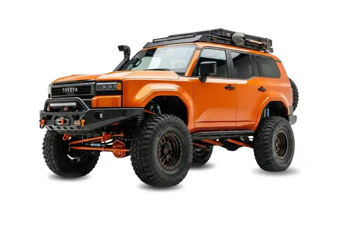 Pomarańczowy Toyota z terenowym wyposażeniem, gotowy na przygody. Te kampery terenowe to marzenie każdego podr&oacute;żnika.