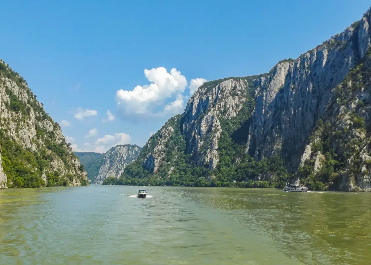 Rejs przez skalne wąwozy, gdzie rzeka tworzy żelazną bramę. Dwa statki płyną po zielonej wodzie.