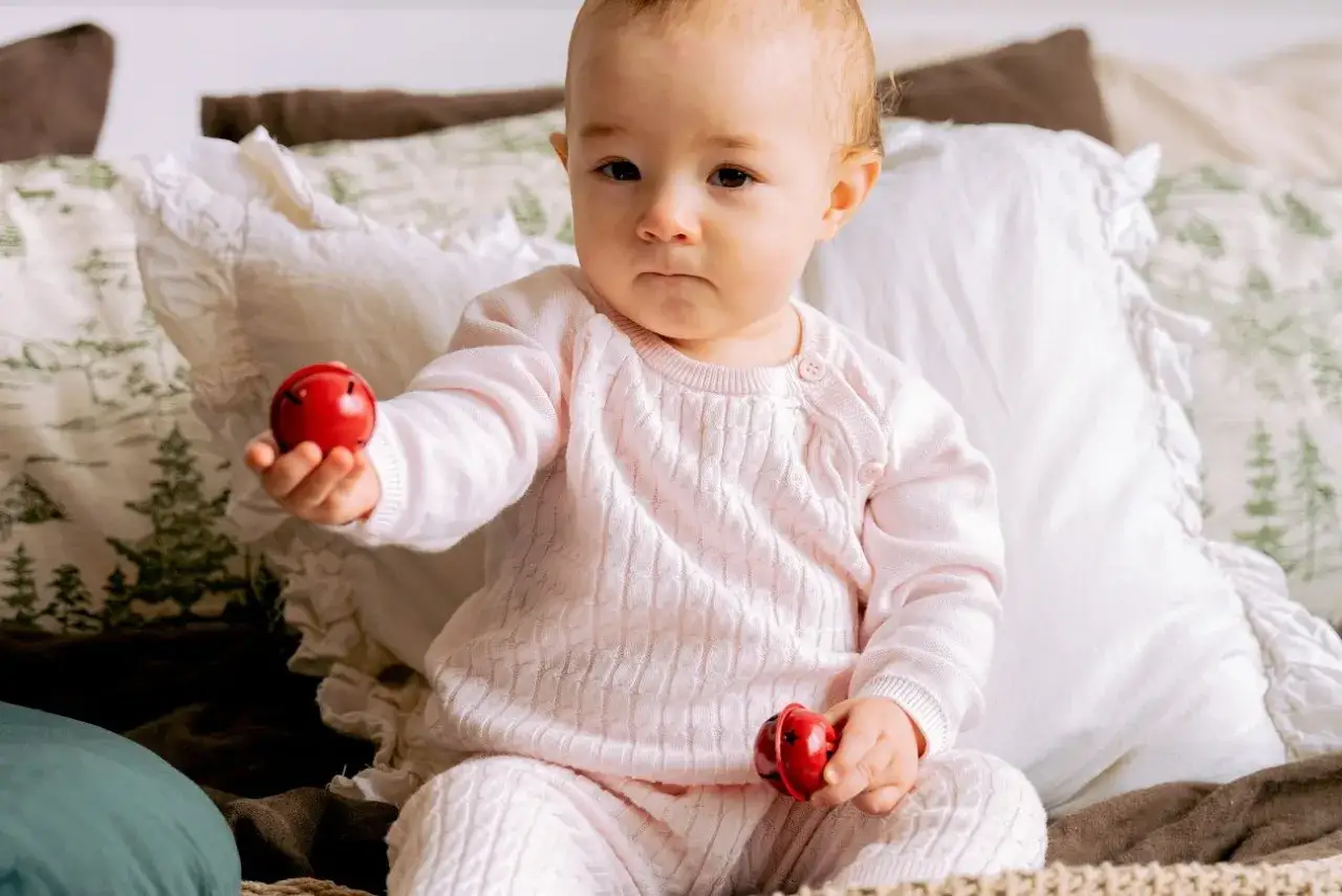 szczęśliwe niemowlę bawiące się rączkami