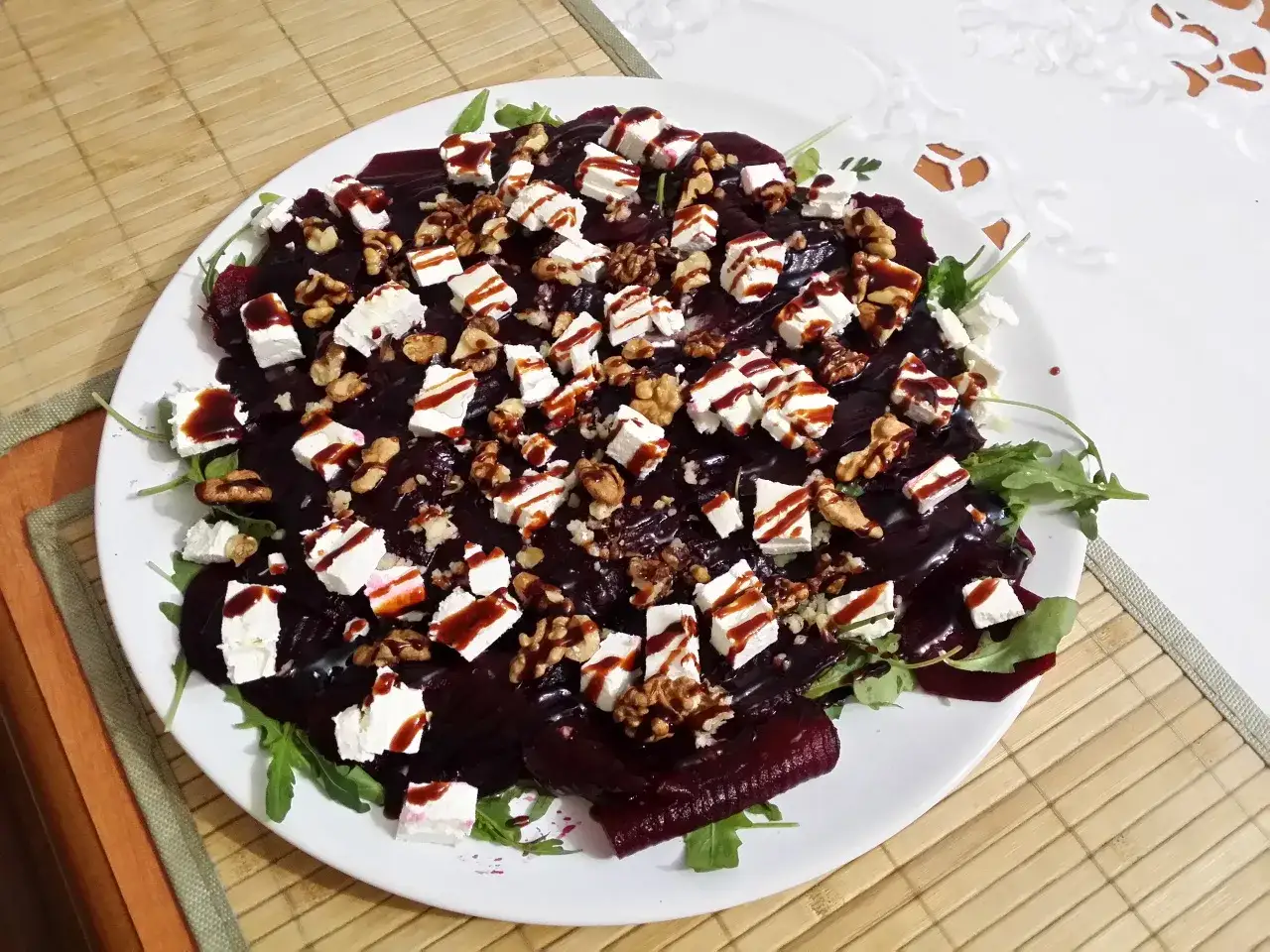 Pyszne carpaccio z buraka z fetą, orzechami włoskimi i sosem balsamicznym na talerzu.