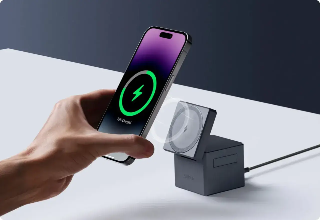 Dłoń zbliża iPhone'a do ładowarki bezprzewodowej. Czy ładowanie bezprzewodowe niszczy baterie? Niekoniecznie, jeśli używasz dobrej jakości akcesoriów.