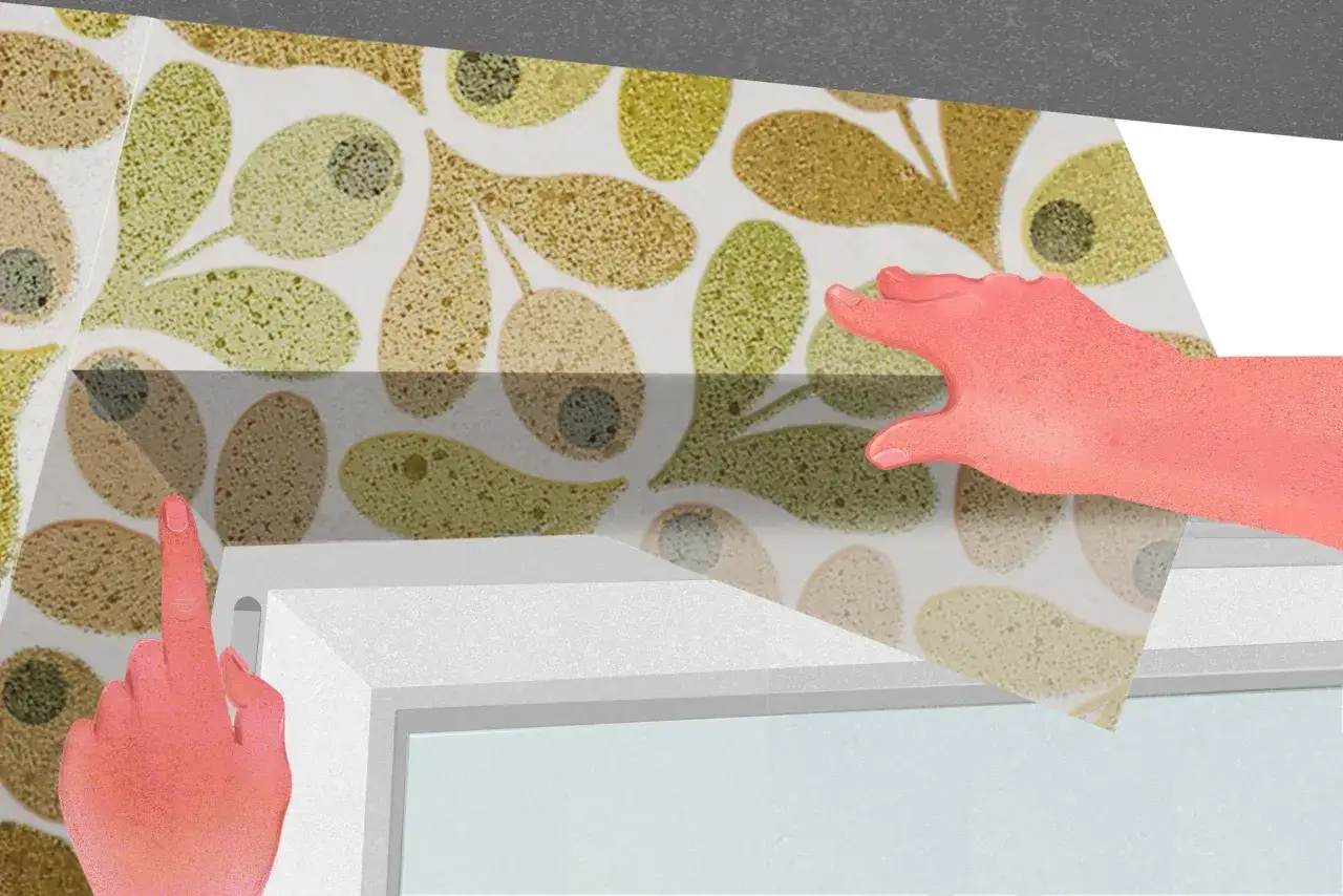 Dłonie przytrzymują tapetę z liśćmi, przygotowując tapetowanie przy otworach okiennych i drzwiowych.