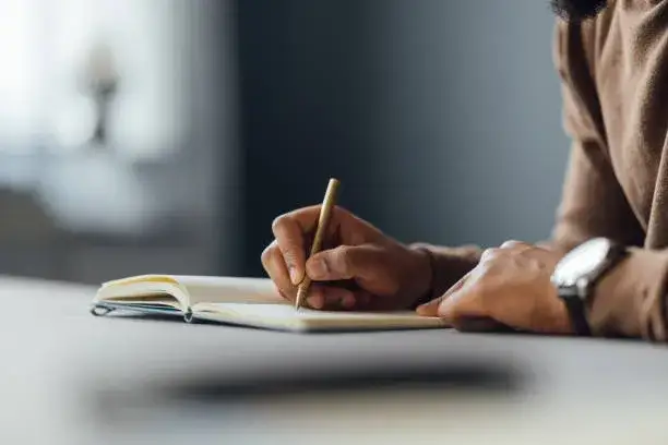 dziennikarz piszący notatki w notesie podczas rozmowy