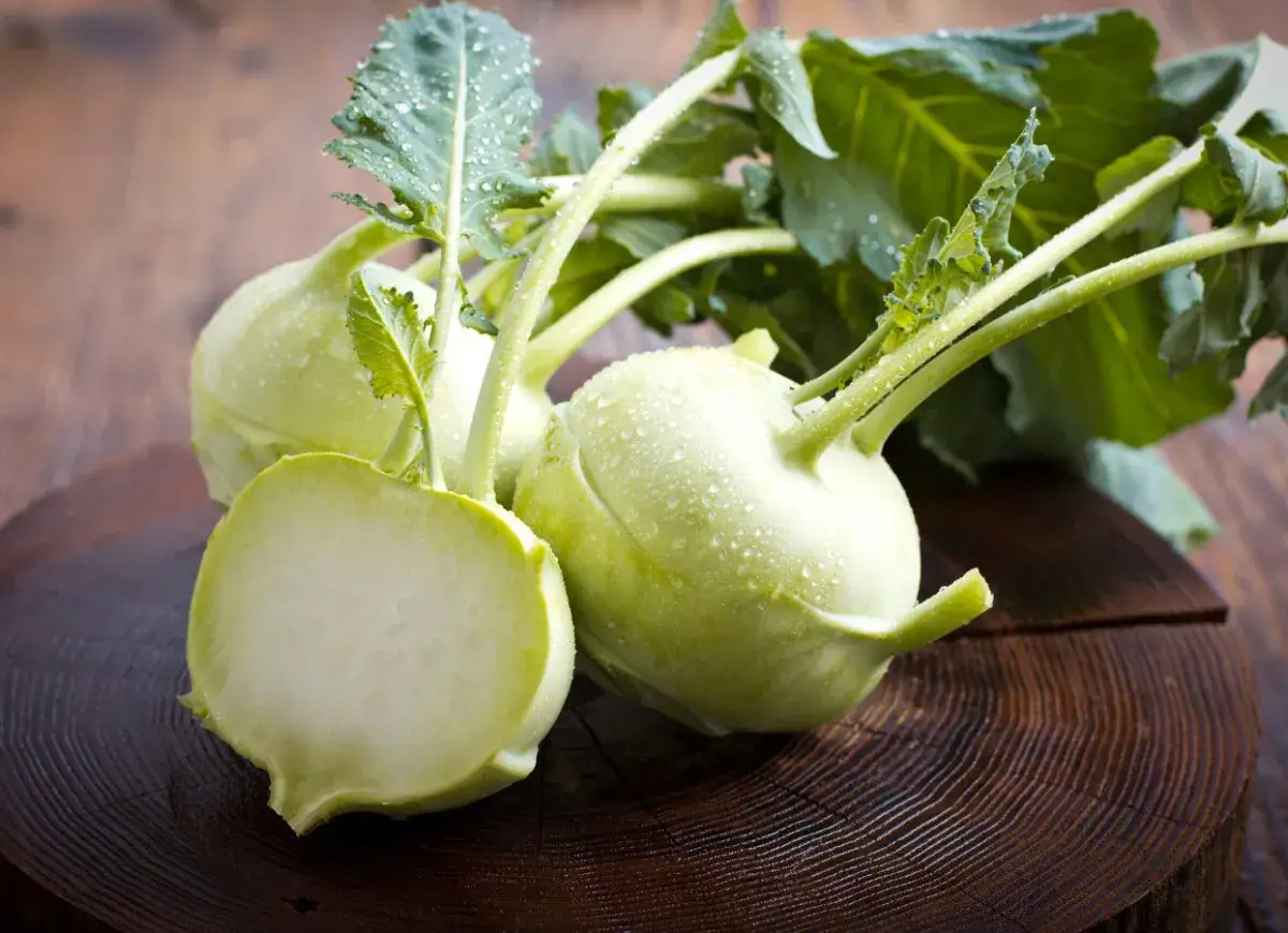 Świeże kalarepy z kroplami wody na drewnianym tle. Odkryj niezwykłe kalarepa właściwości i dodaj je do swojej diety!