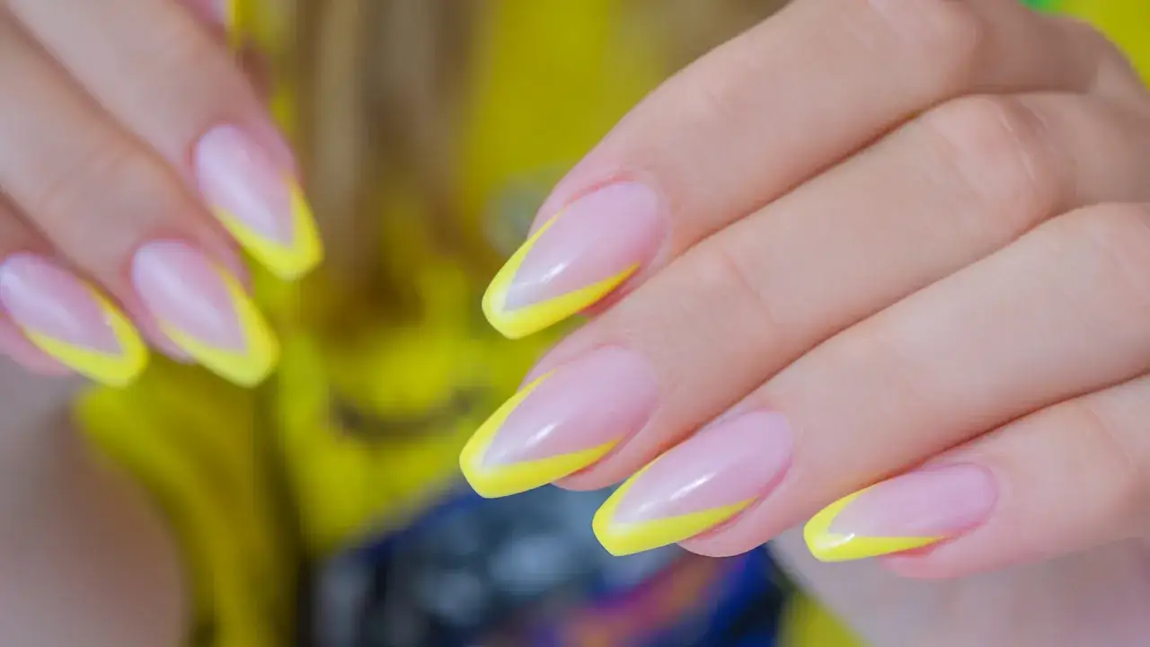 Elegancki french manicure z neonowym, żółtym akcentem na końcówkach paznokci.