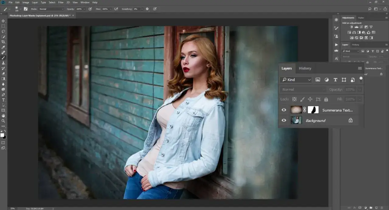 Kobieta w dżinsowej kurtce na tle drewnianej ściany. Panel warstw w programie Photoshop pokazuje, jak działa maskowanie. Photoshop co to?