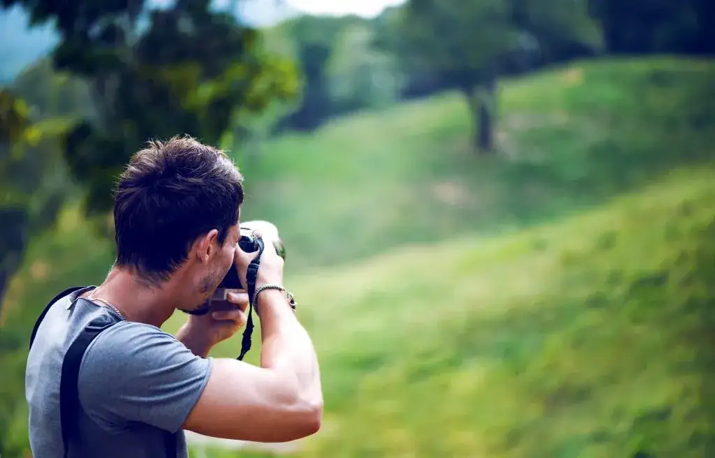 fotograf amator z aparatem bezlusterkowym w plenerze