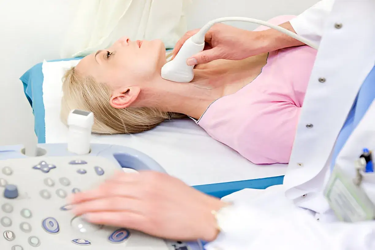 Badanie USG szyi u kobiety, kt&oacute;re może pom&oacute;c w diagnostyce miażdżycy. Lekarz wykonuje badanie, a pacjentka leży na kozetce.
