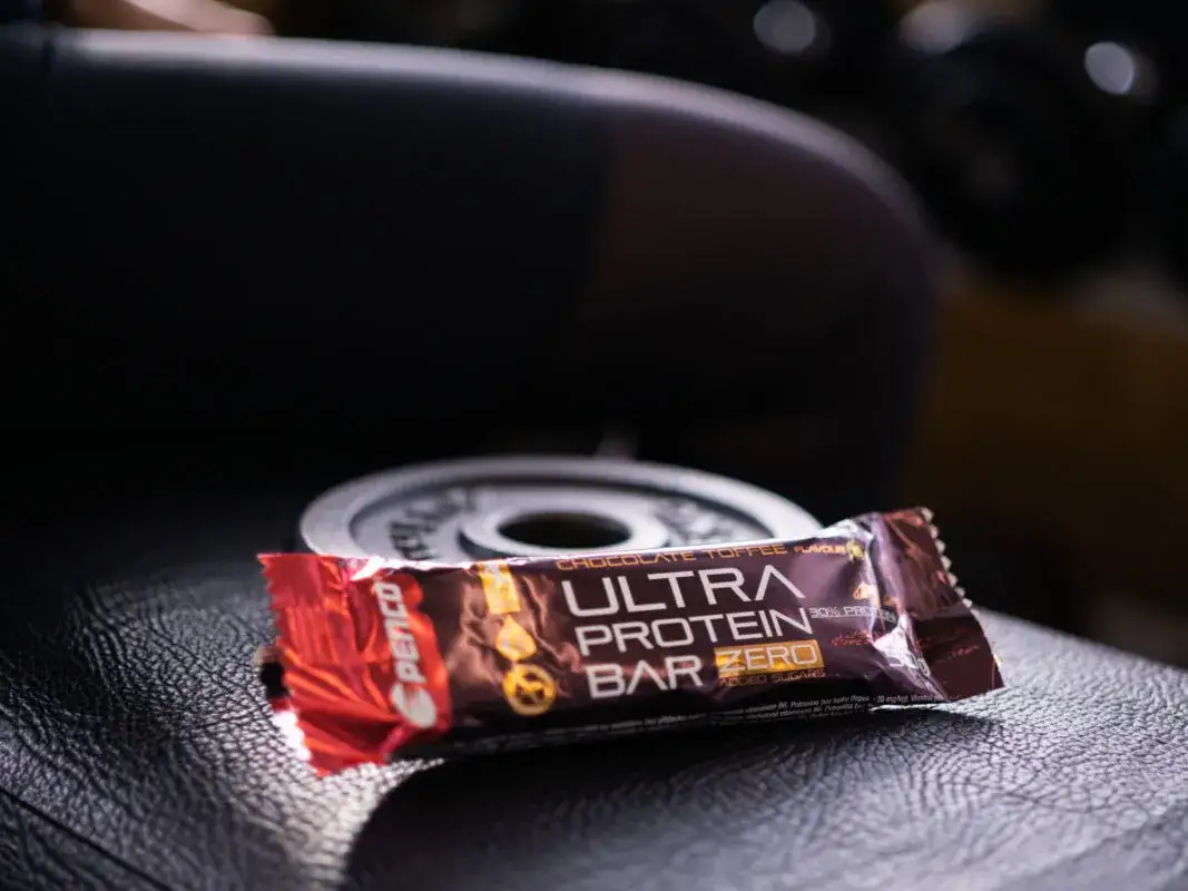 osoba jedząca baton proteinowy po treningu