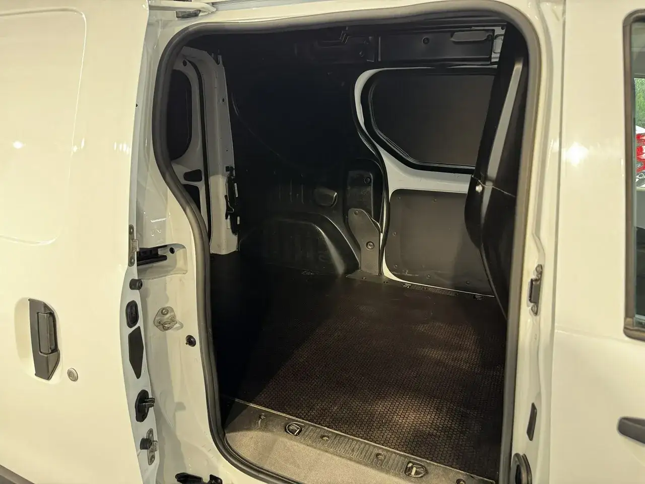 Pusta przestrzeń ładunkowa białego Dacia Dokker Stepway, gotowa na przewóz towarów.