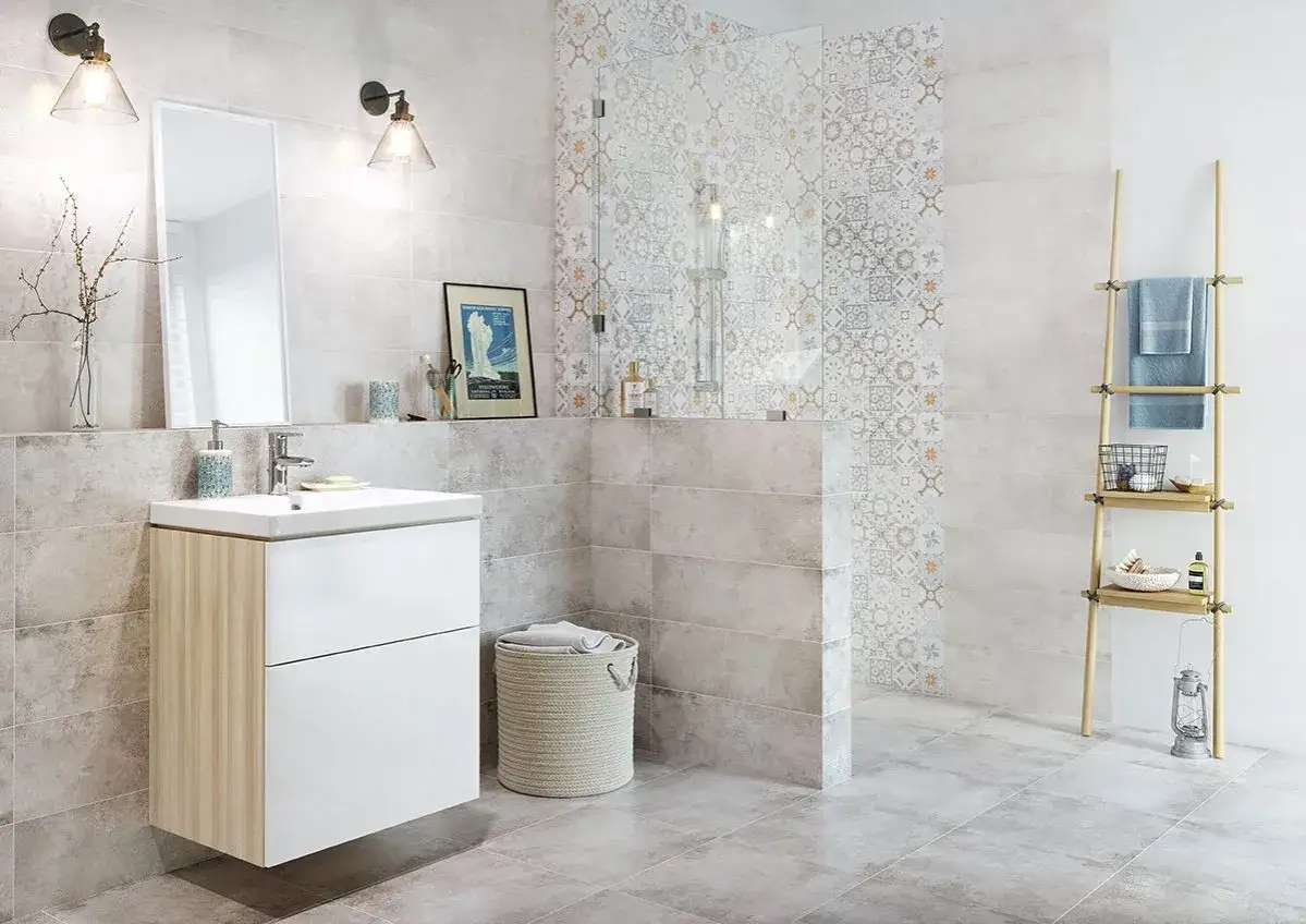 Łazienka z prysznicem ozdobionym płytkami we wzory marokańskie. Jasne ściany i podłoga tworzą spokojną bazę dla orientalnych akcent&oacute;w.