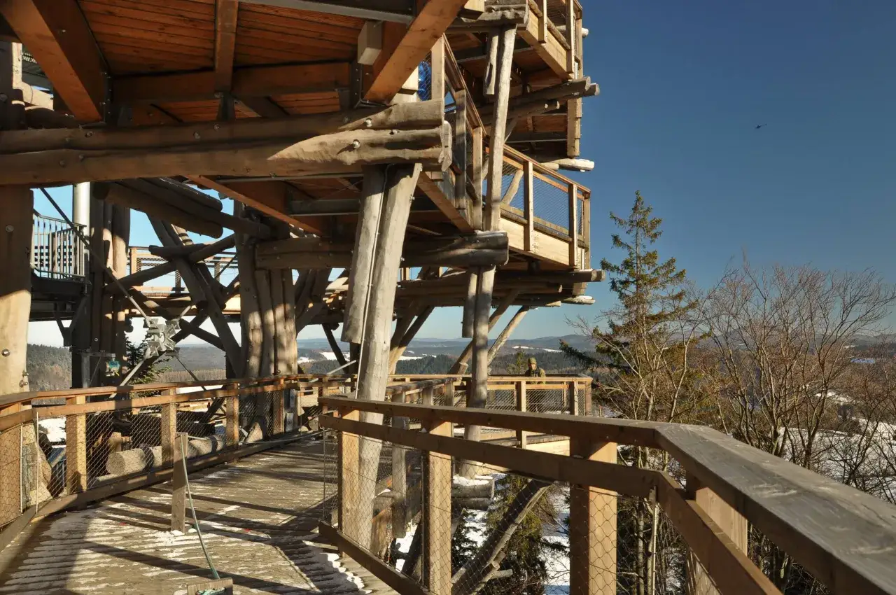 Drewniana konstrukcja wieży widokowej, przypominająca bac&oacute;wkę kr&oacute;lowej Jadwigi, wznosi się nad zimowym krajobrazem.