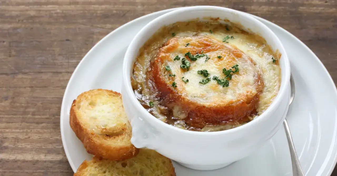 Aksamitna zupa cebulowa z przyprawami, zapieczona pod serem z grzankami.