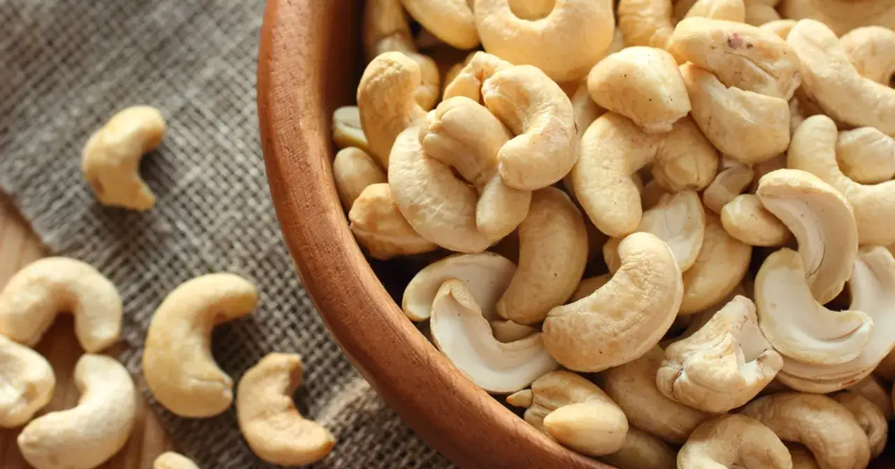 Orzechy nerkowca w drewnianej misce. Niska zawartość cukru sprawia, że orzechy nerkowca mają niski indeks glikemiczny.