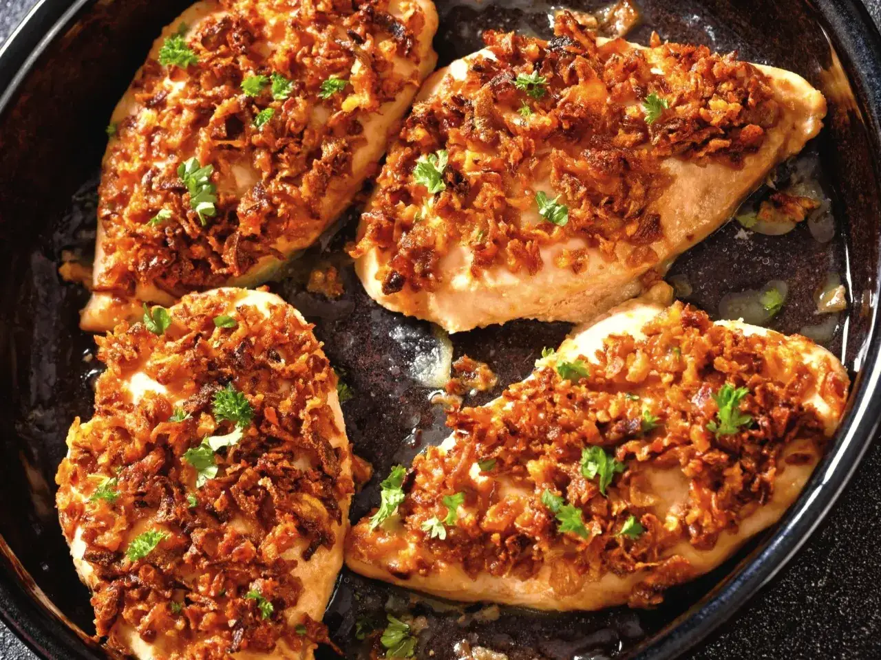 Pyszne piersi z kurczaka zapiekane z chrupiącą cebulką. Idealne co na obiad z piersi z kurczaka, posypane natką pietruszki.