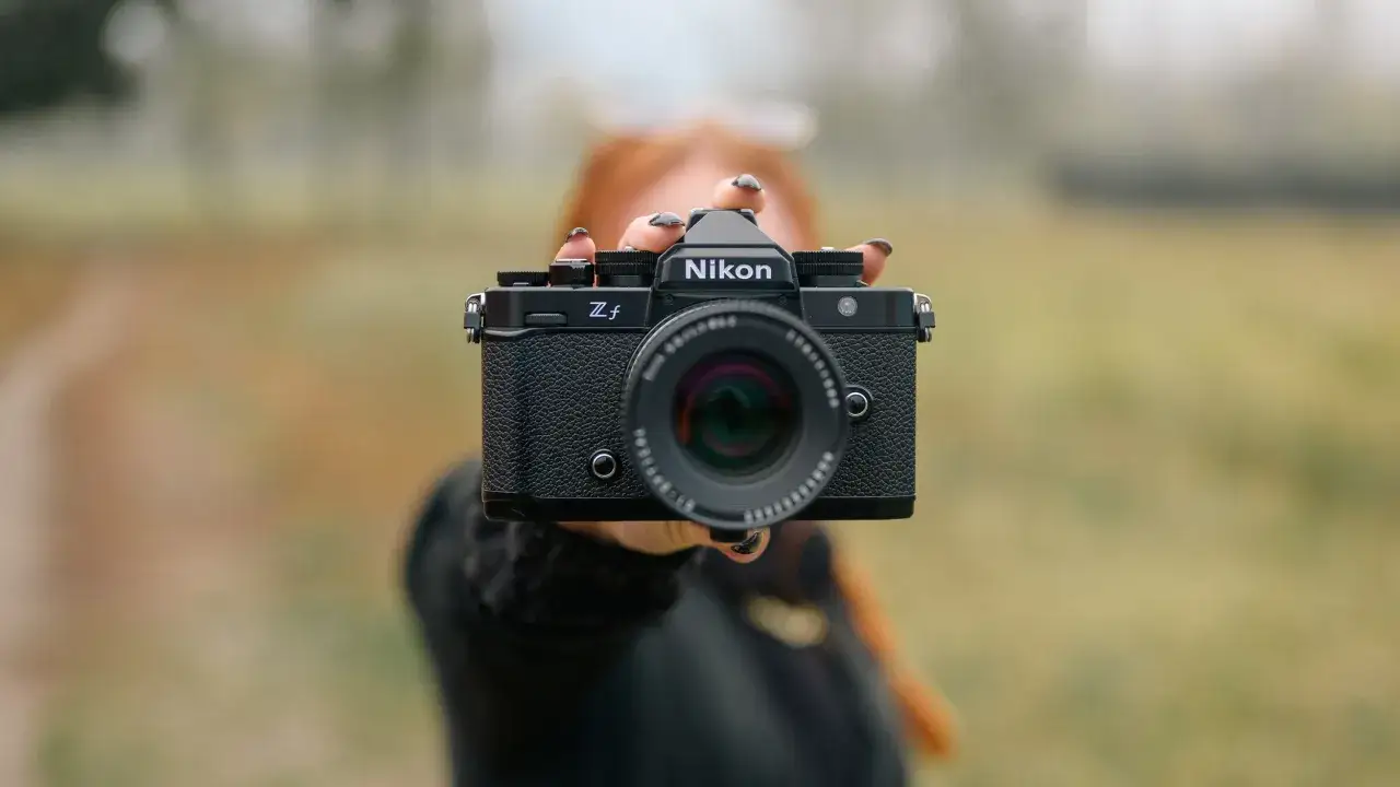 Ręce trzymają aparat Nikon Zfc, gotowy do test&oacute;w.