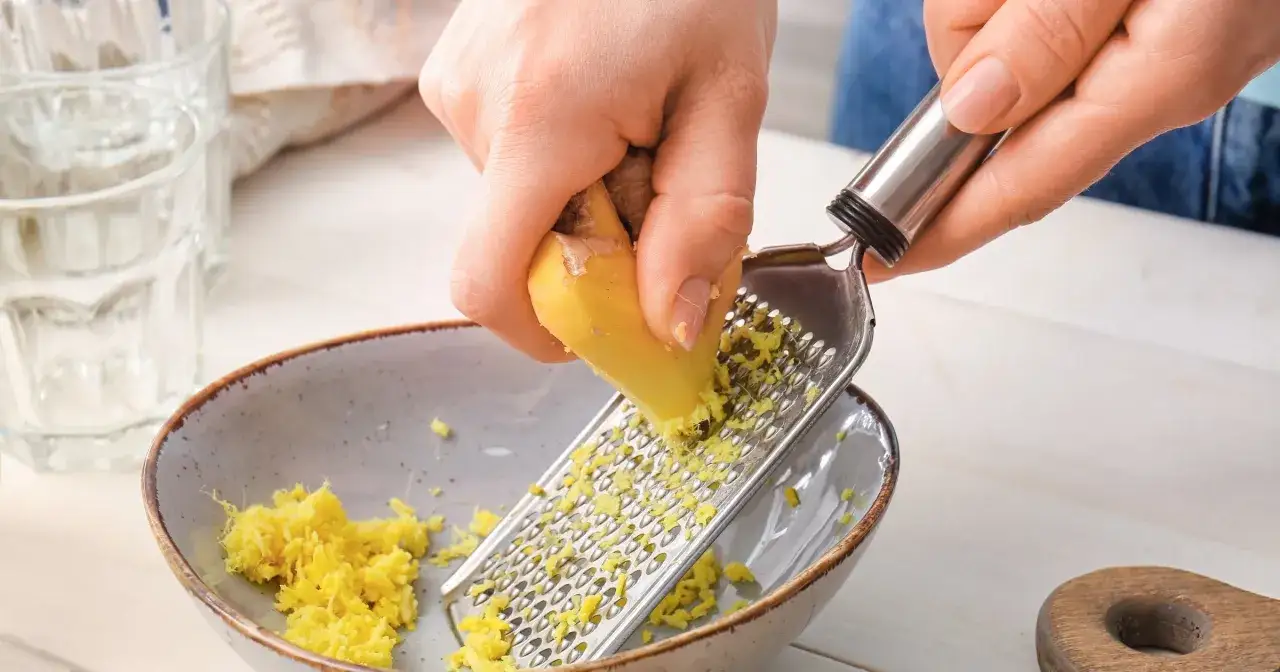 Ręce trą imbir na tarce. To naturalny sposób na zgagę.