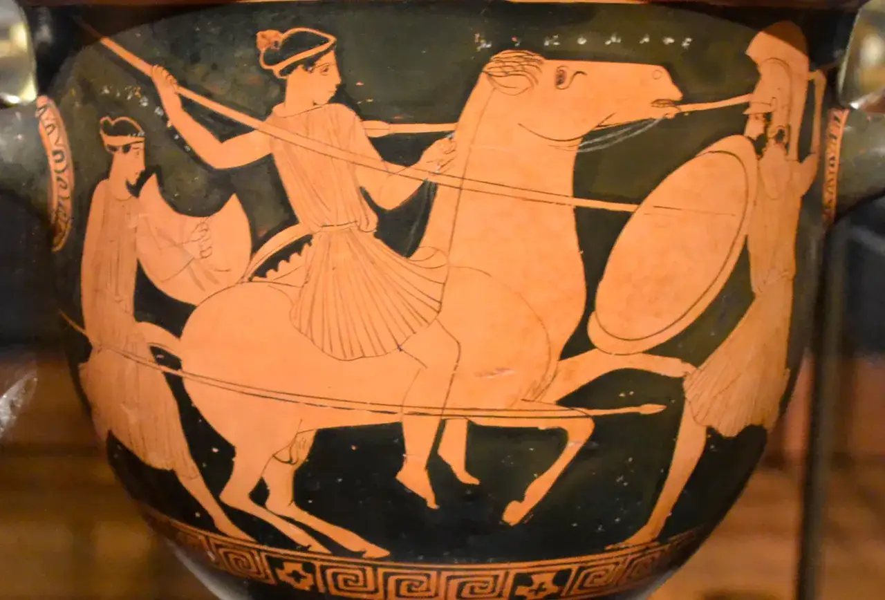 Starożytny wazon z czarnymi postaciami przedstawia Amazonkę na koniu, walczącą z wojownikiem.