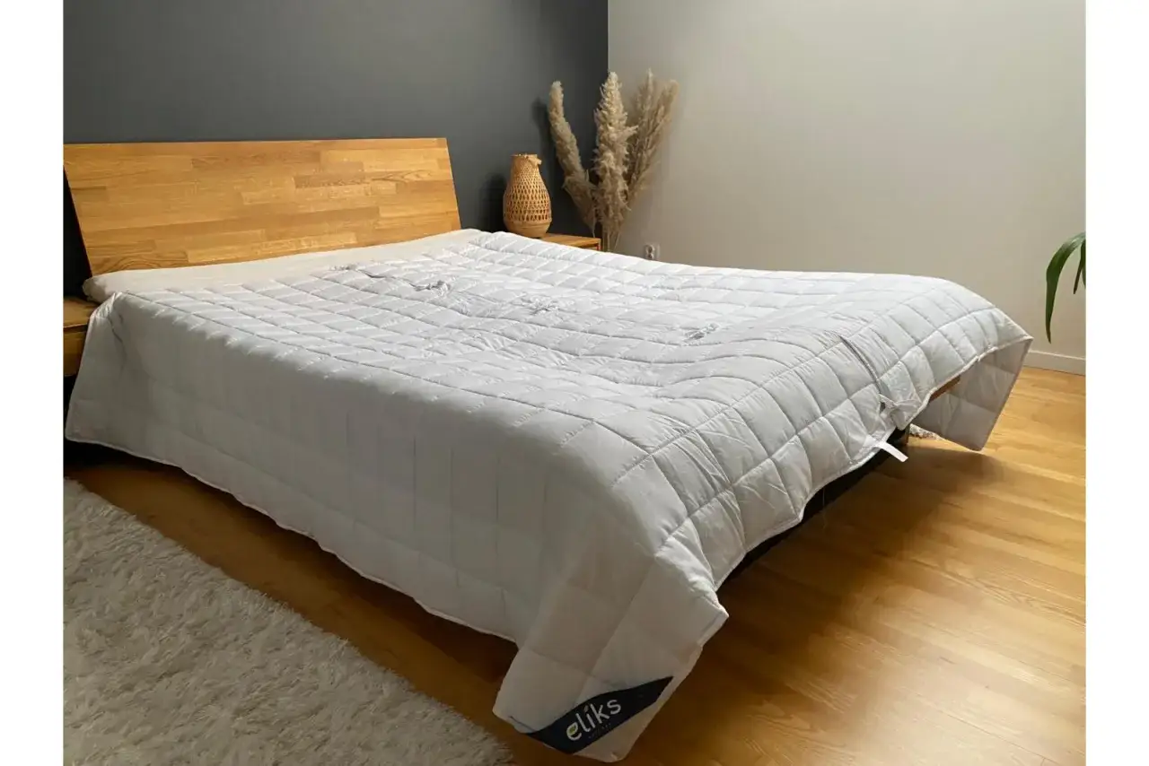 Biała kołdra obciążeniowa na łóżku. Dowiedz się, jak dobrać idealną kołdrę obciążeniową dla siebie.