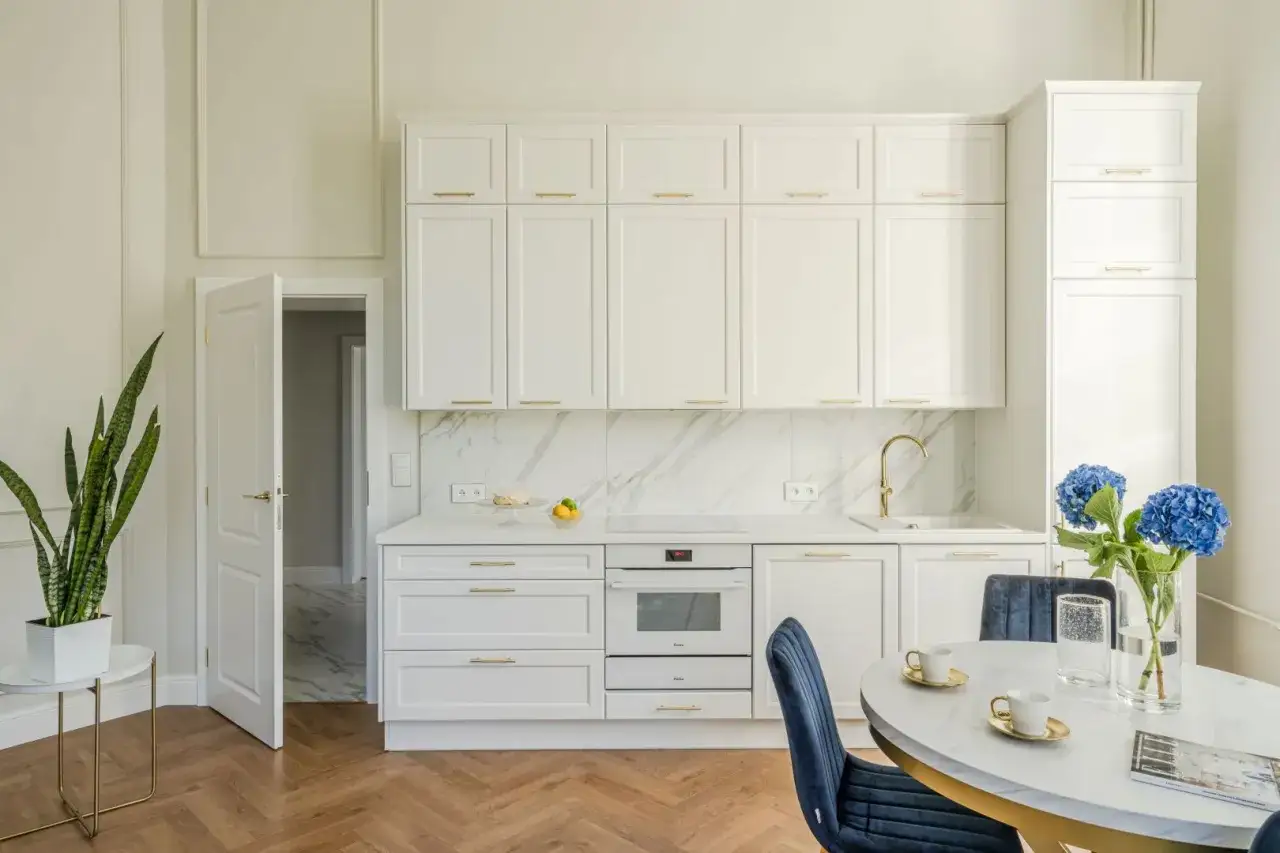Nowoczesna kuchnia z białymi szafkami i marmurowym backsplash. Elegancka żywica na ścianę w kuchni dodaje blasku.