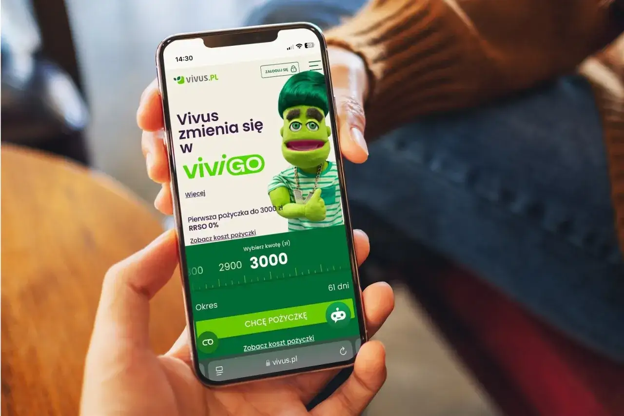 Na ekranie telefonu Vivus.pl widać zieloną postać, która zachęca do wzięcia pierwszej pożyczki do 3000 zł RRSO 0%. Czy Vivus jest bezpieczny? Aplikacja oferuje szybkie pożyczki.