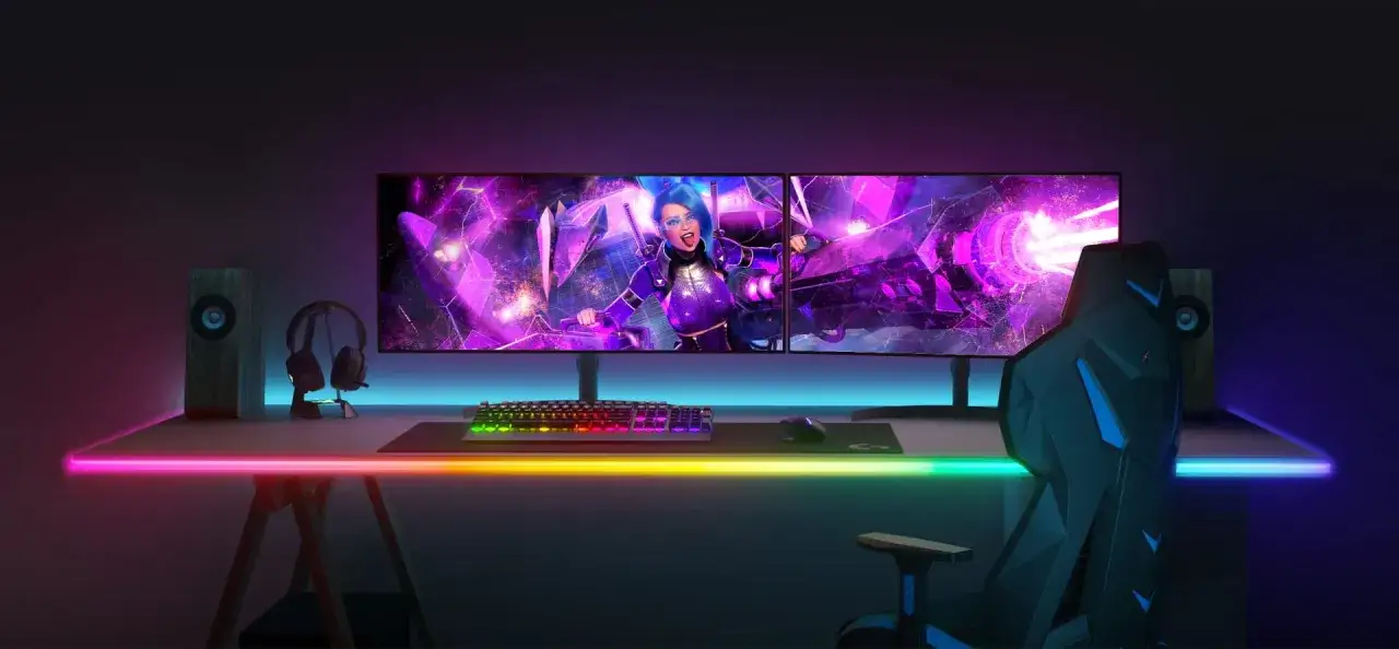 Stolik gracza z podświetleniem led, dwoma monitorami z grafiką anime, kolorową klawiaturą i gamingowym fotelem.