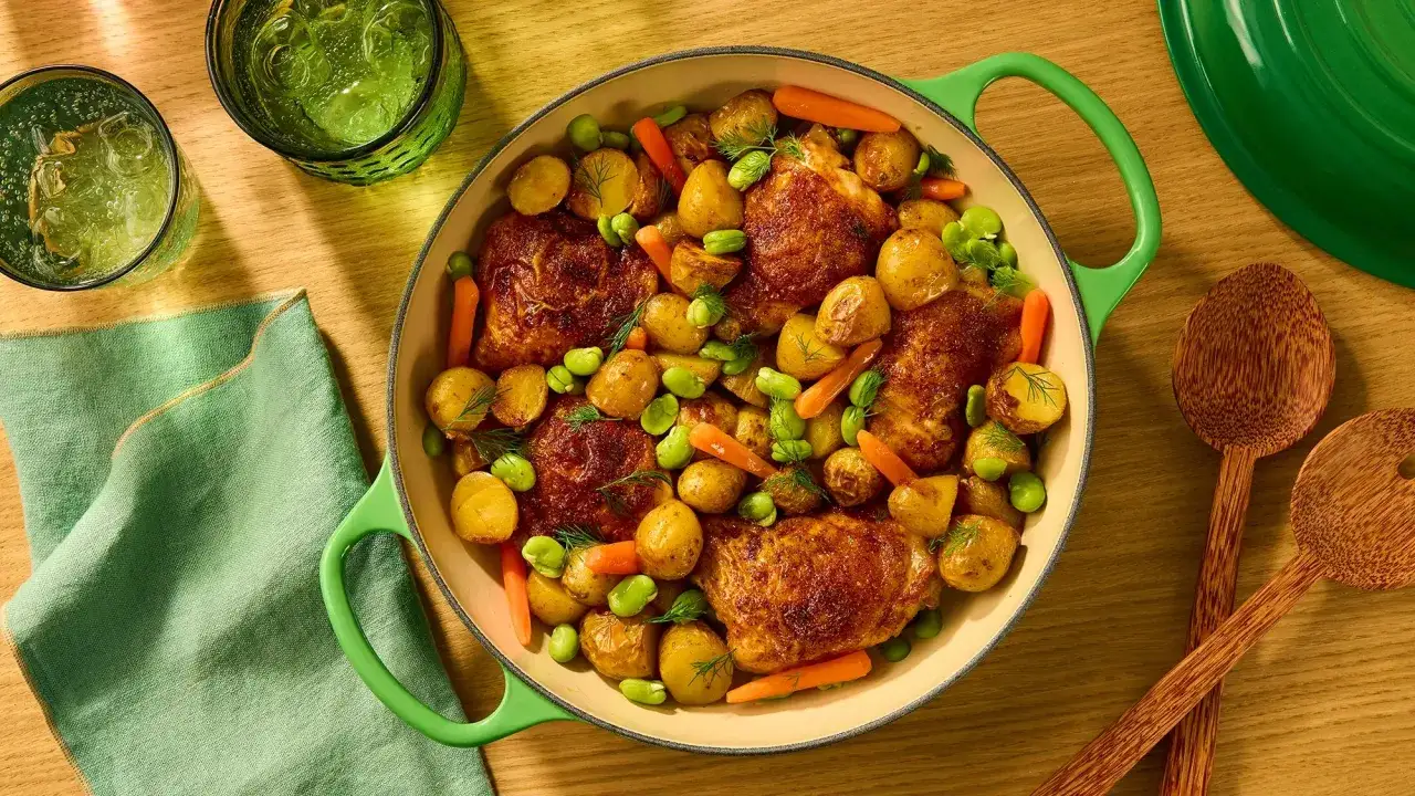 Złocisty kurczak z ziemniaczkami, fasolką i marchewką w zielonej patelni.