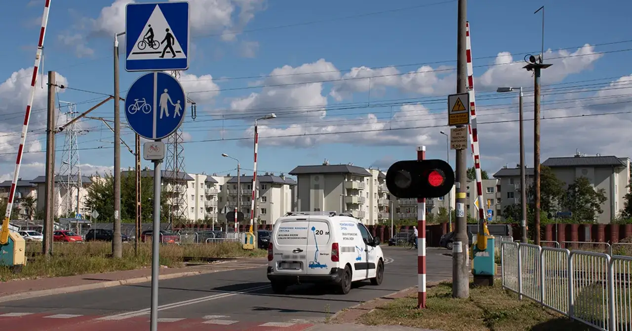 Przejazd kolejowy z czerwonym światłem. Kierowca zastanawia się, jaki mandat za przejechanie na czerwonym świetle grozi w takiej sytuacji.