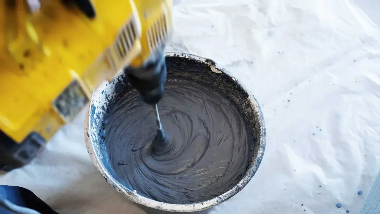 Mieszanie zaprawy murarskiej za pomocą mieszadła. Kluczowe są odpowiednie zaprawa murarska proporcje, by uzyskać idealną konsystencję.