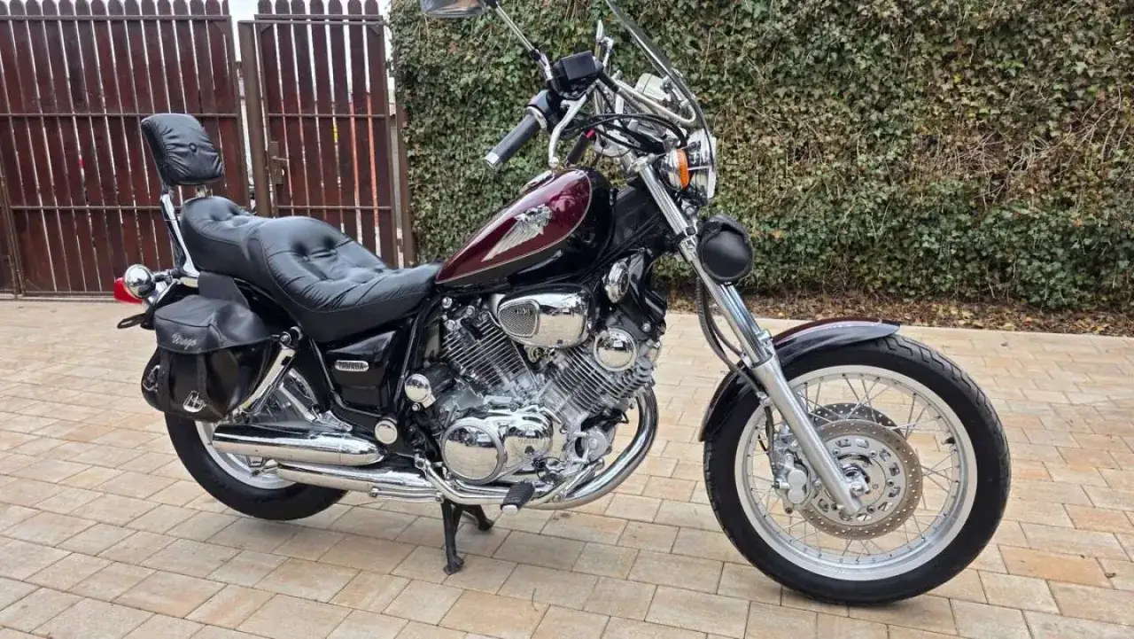 Klasyczny motocykl Yamaha Virago w kolorze wiśniowym, z czarnymi skórzanymi sakwami i wygodnym siedzeniem, gotowy na podróż.