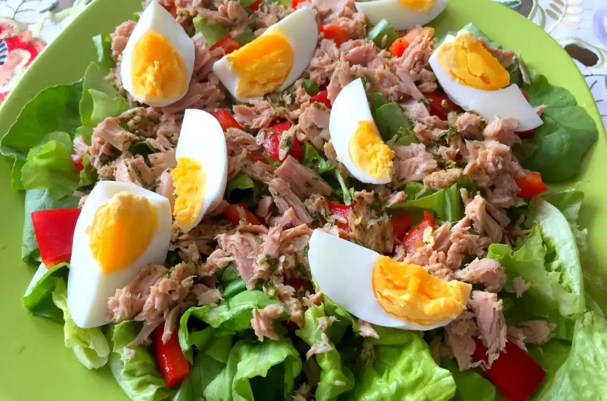 Pyszna sałatka z tuńczykiem i jajkiem na chrupiącej sałacie z papryką. Idealna na lekki posiłek.