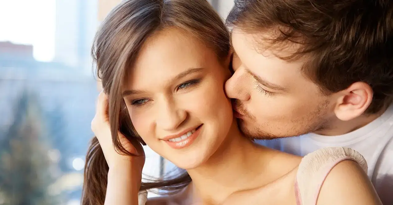 Delikatny pocałunek w szyję, symbol czułości i bliskości.