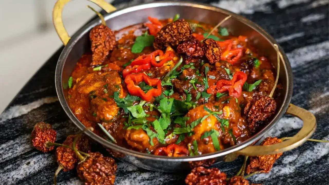 Ostre curry z kurczaka, ozdobione świeżymi papryczkami i suszonymi chili. To danie to prawdziwe wyzwanie dla miłośników najostrzejszego jedzenia na świecie.