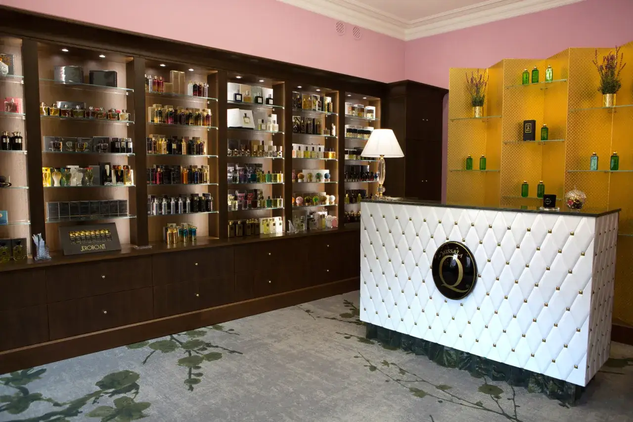 wnętrze eleganckiej perfumerii niszowej z p&oacute;łkami pełnymi flakon&oacute;w