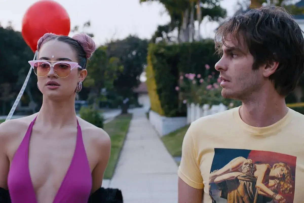 Para odkryć tajemnice Silver Lake, młoda kobieta z różowymi włosami i mężczyzna w żółtej koszulce idą chodnikiem.