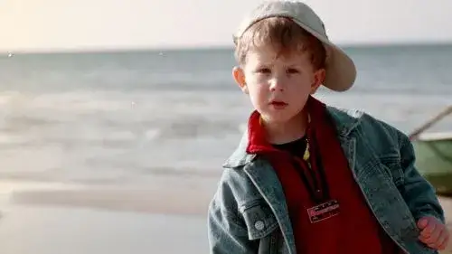 Dziecko w czapce i kurtce na plaży