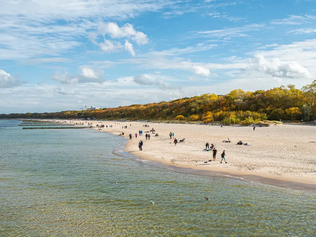 Piękna plaża w Kołobrzegu jesienią. Ludzie spacerują, odpoczywają. Zastanawiasz się, ile kosztuje klimatyczne w Kołobrzegu?