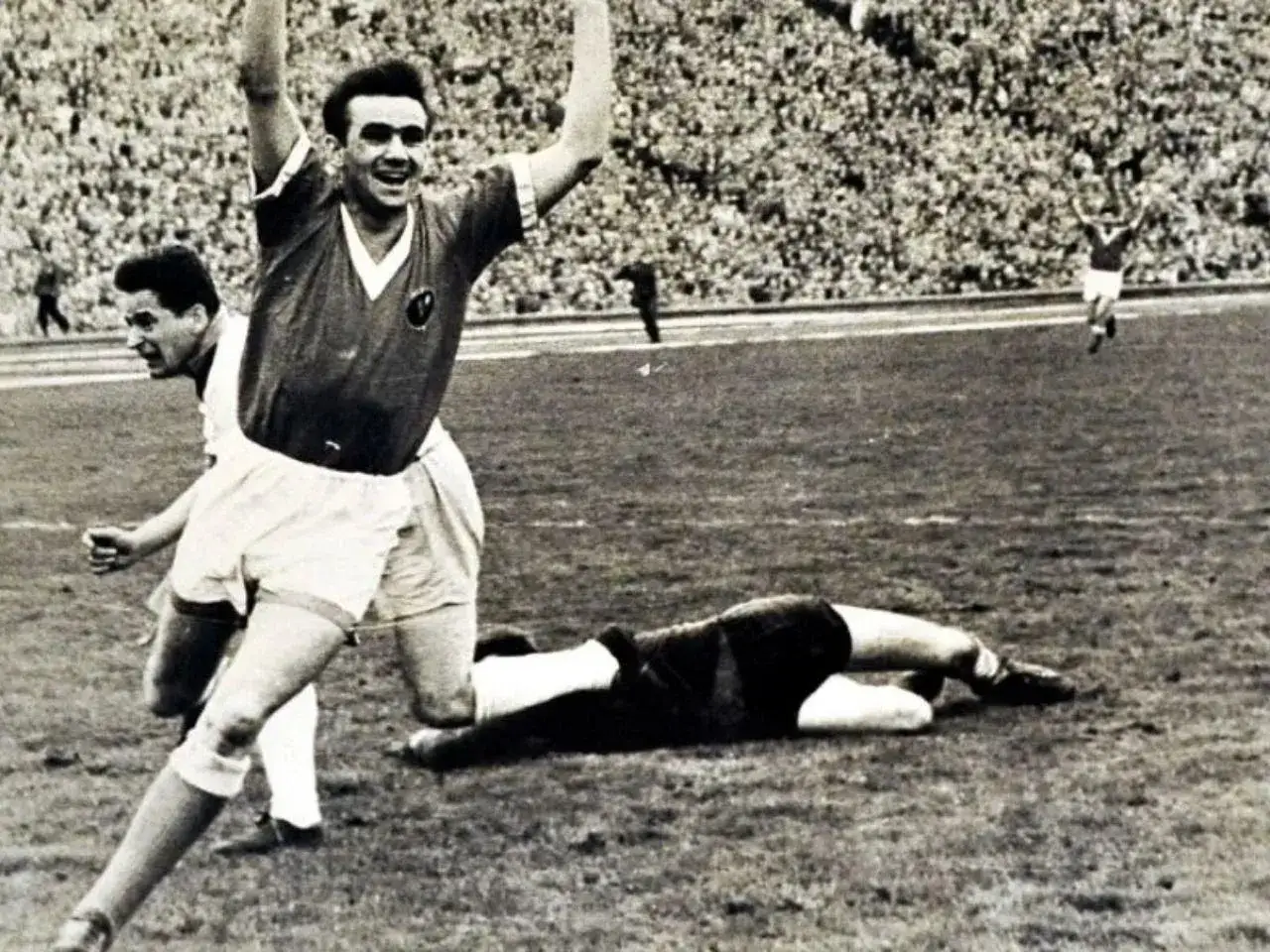 Piłkarz świętuje bramkę na tle trybun. To obraz z historii najstarszych klubów piłkarskich w Polsce.