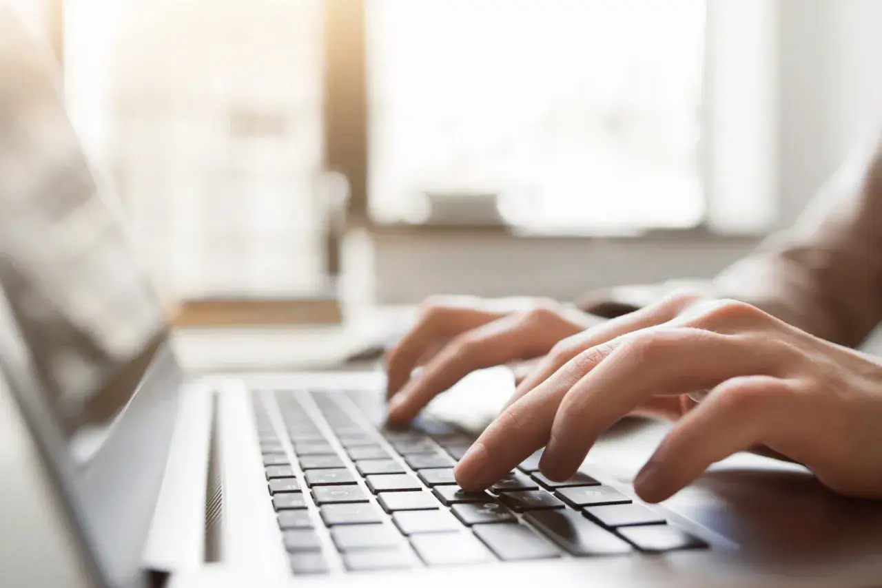 osoba pisząca opinię na laptopie