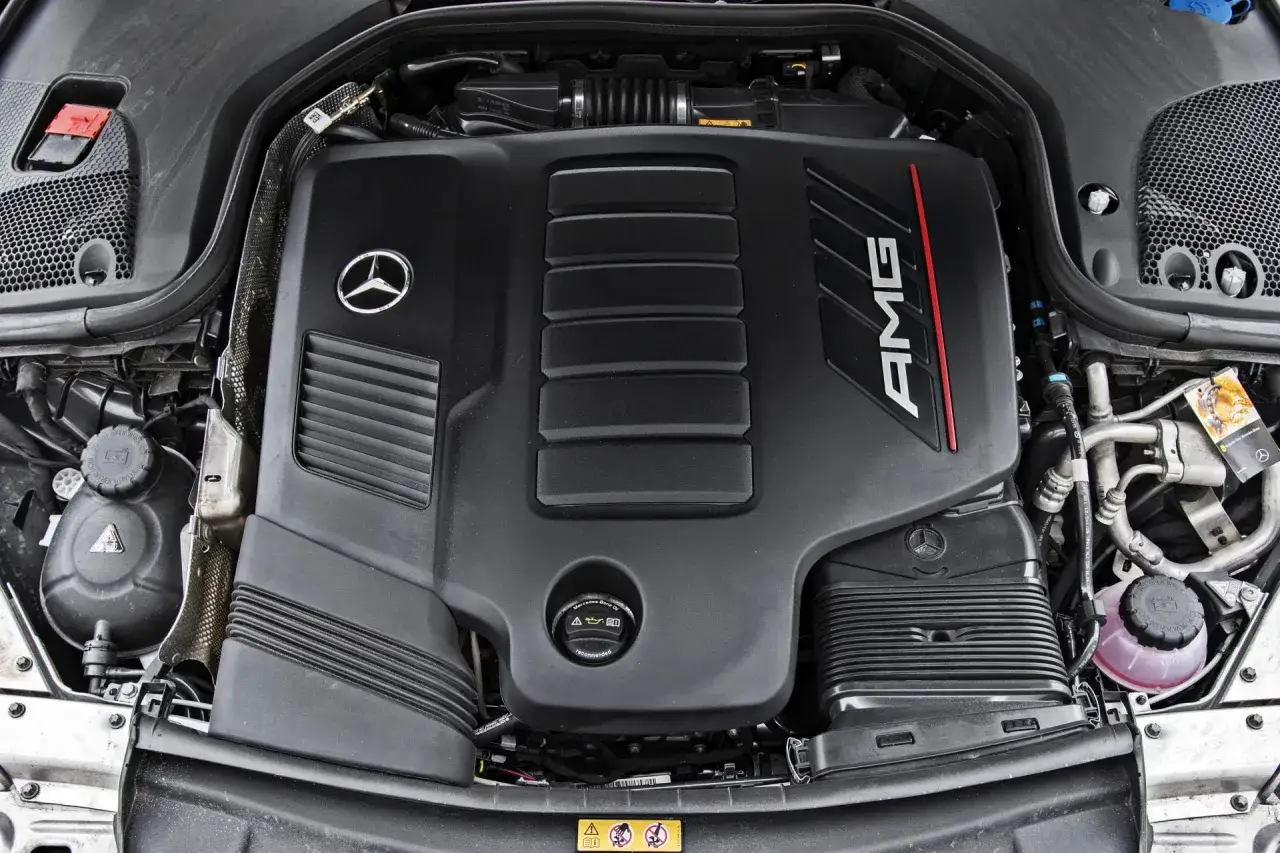 Silnik AMG w Mercedes-Benz E-Class. Czarna pokrywa z logo gwiazdy i napisem AMG.