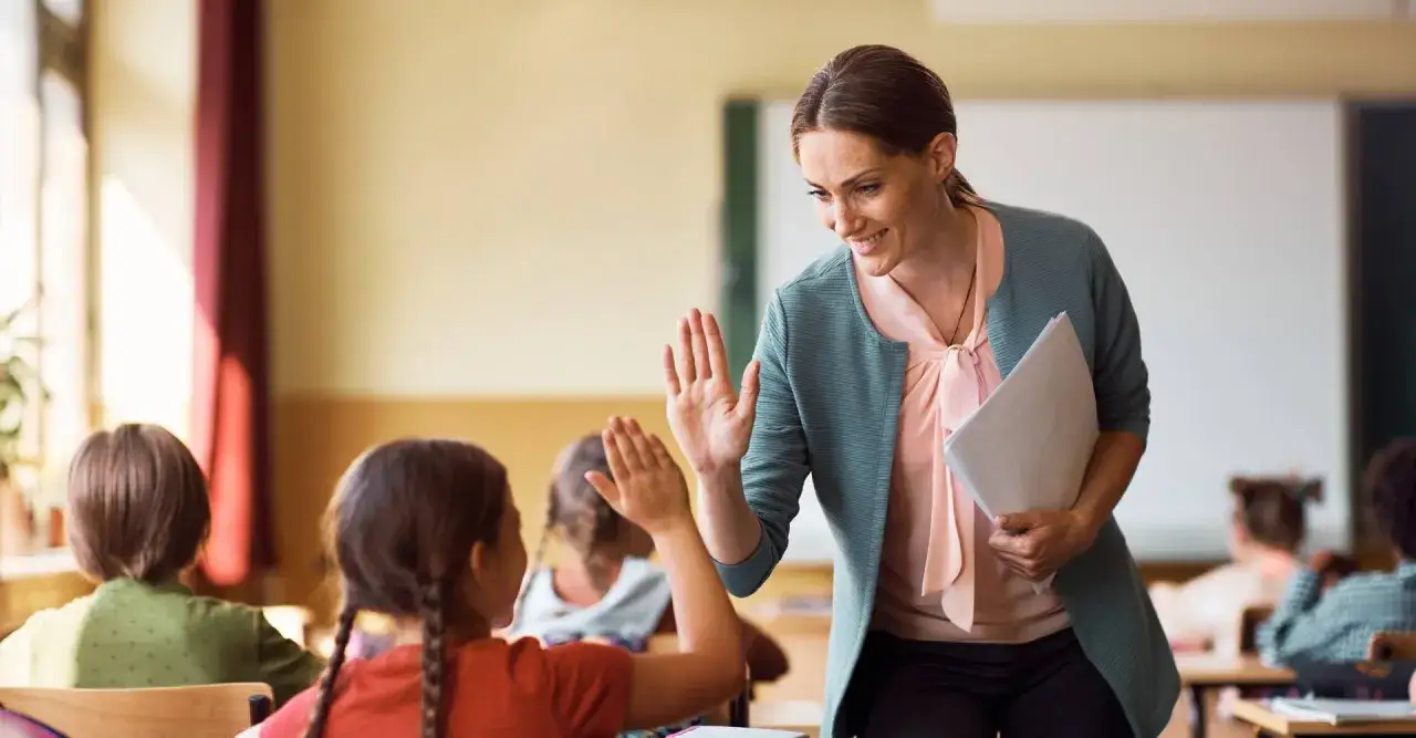 Uczeń i nauczyciel wsp&oacute;lnie pracujący nad materiałami, symbolizujący indywidualne konsultacje