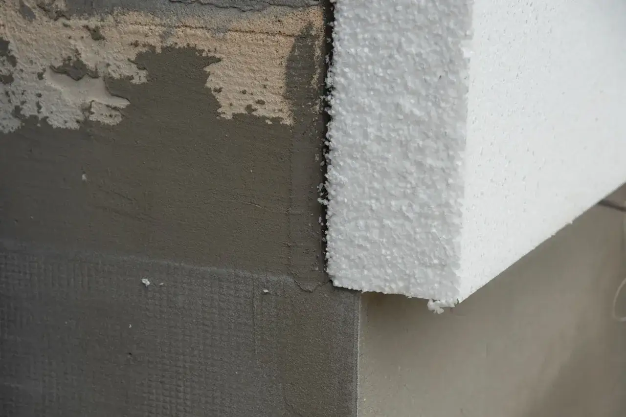 Fragment ocieplenia budynku: szary tynk i biały styropian. Czy to styrobeton czy styropian?