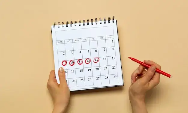 kalendarz z zaznaczonymi datami, kobieca ręka trzymająca kalendarz
