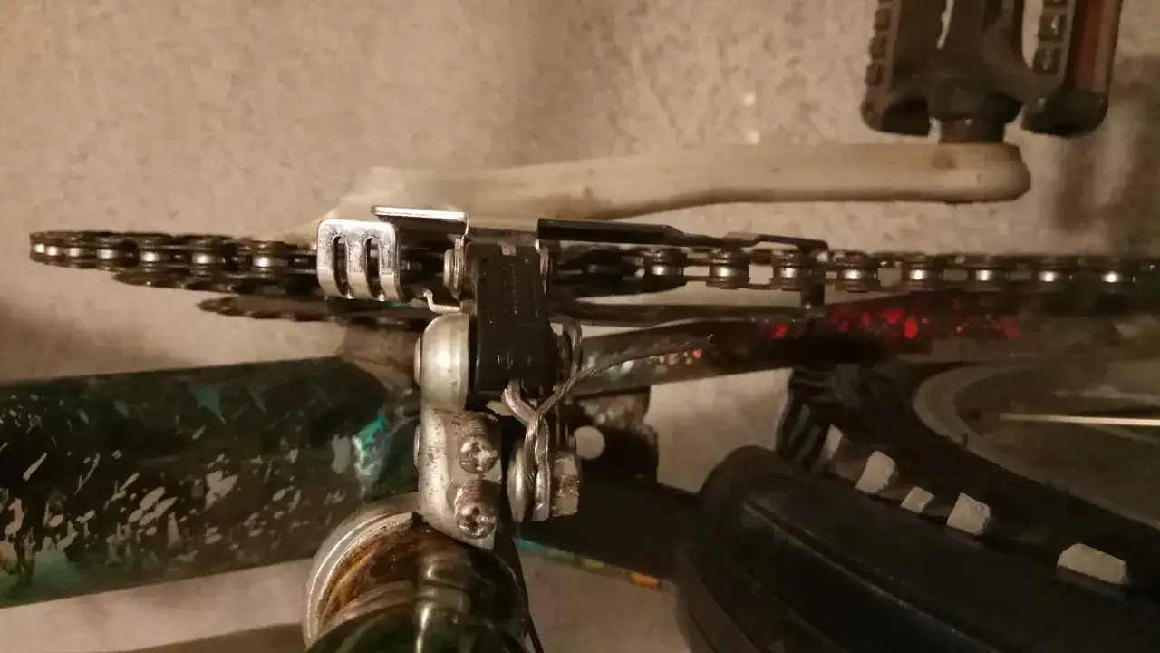 Mechanizm przerzutki rowerowej, gdzie przednia przerzutka nie wchodzi na 3. Widoczny łańcuch, zębatki i elementy napędu.