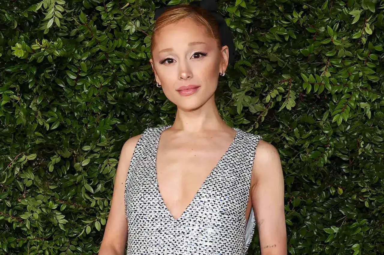 Ariana Grande w błyszczącej sukience, z kokardką na włosach. Mimo choroby, gwiazda prezentuje się promiennie.