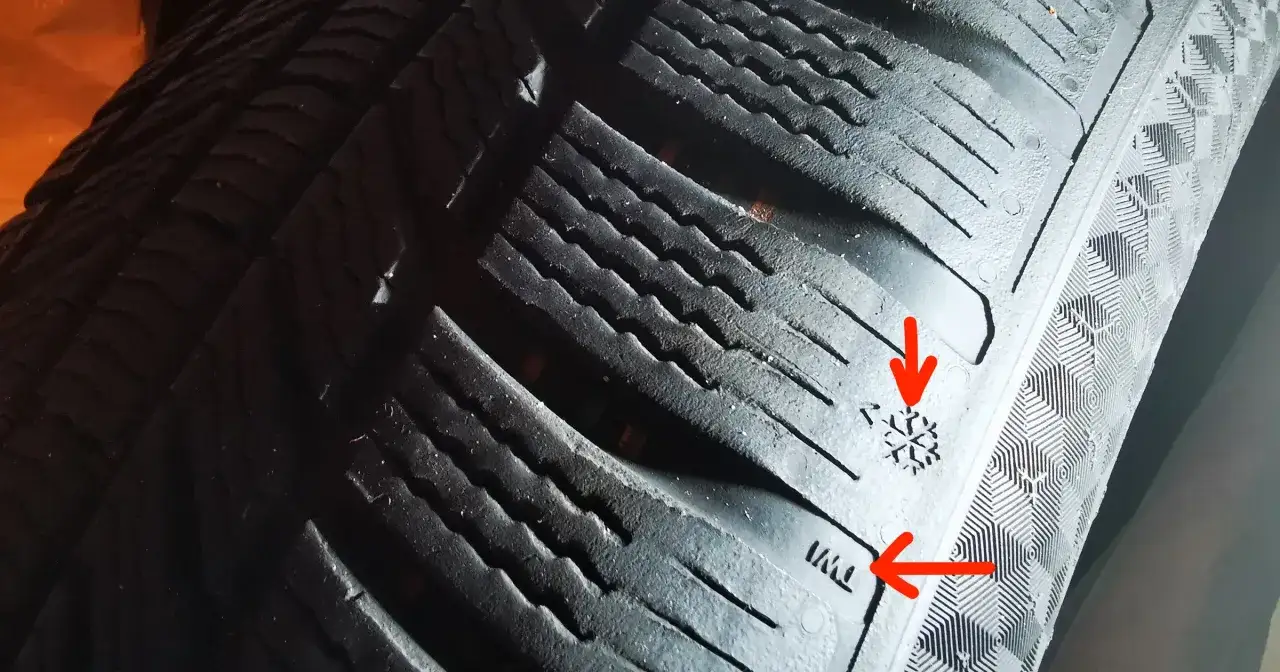 Nowa opona zimowa z bieżnikiem w kształcie płatka śniegu. Widać oznaczenie TWI, które pomaga ocenić, ile mm bieżnika ma nowa opona zimowa.
