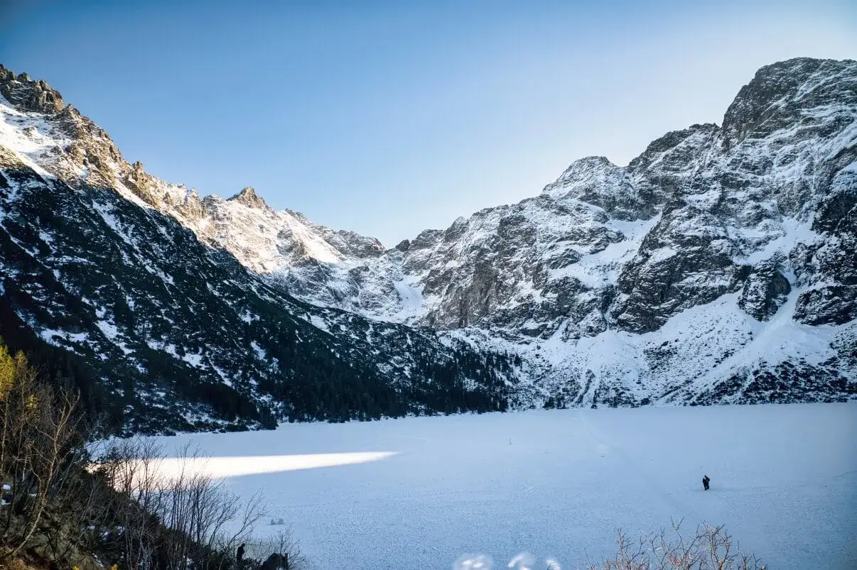 Zimowe Tatry: zamarznięte jezioro Morskie Oko i ośnieżone szczyty. Idealne miejsce na łatwe szlaki w tatrach zimą.
